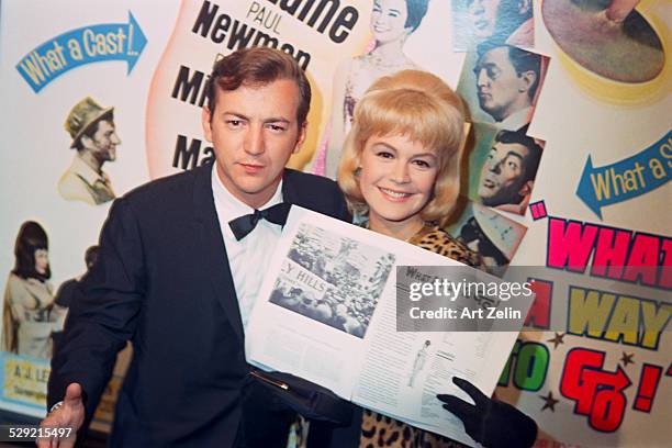 Sandra Dee and Bobby Darin posing in front of a poster for "What a Way to Go" Hollywood .