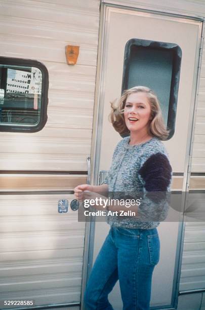 Kathleen Turner wearing a sweater and jeans outside a trailer; circa 1970; New York.