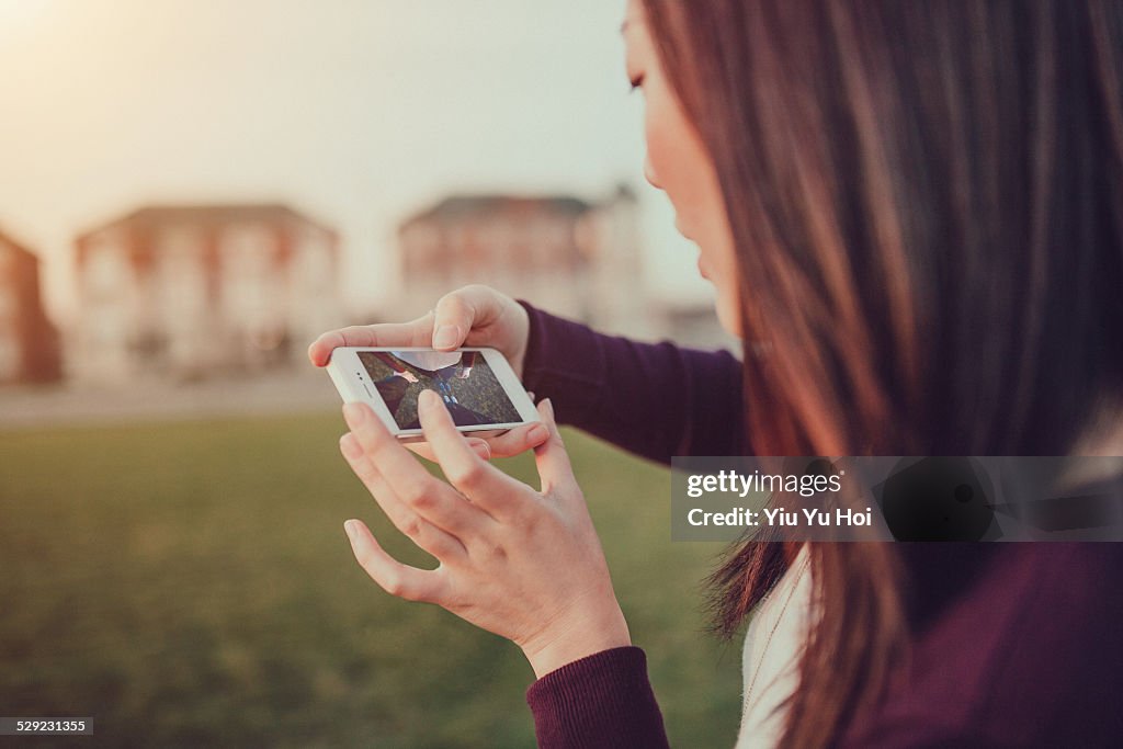 Young lady captures the happy moment by smartphone