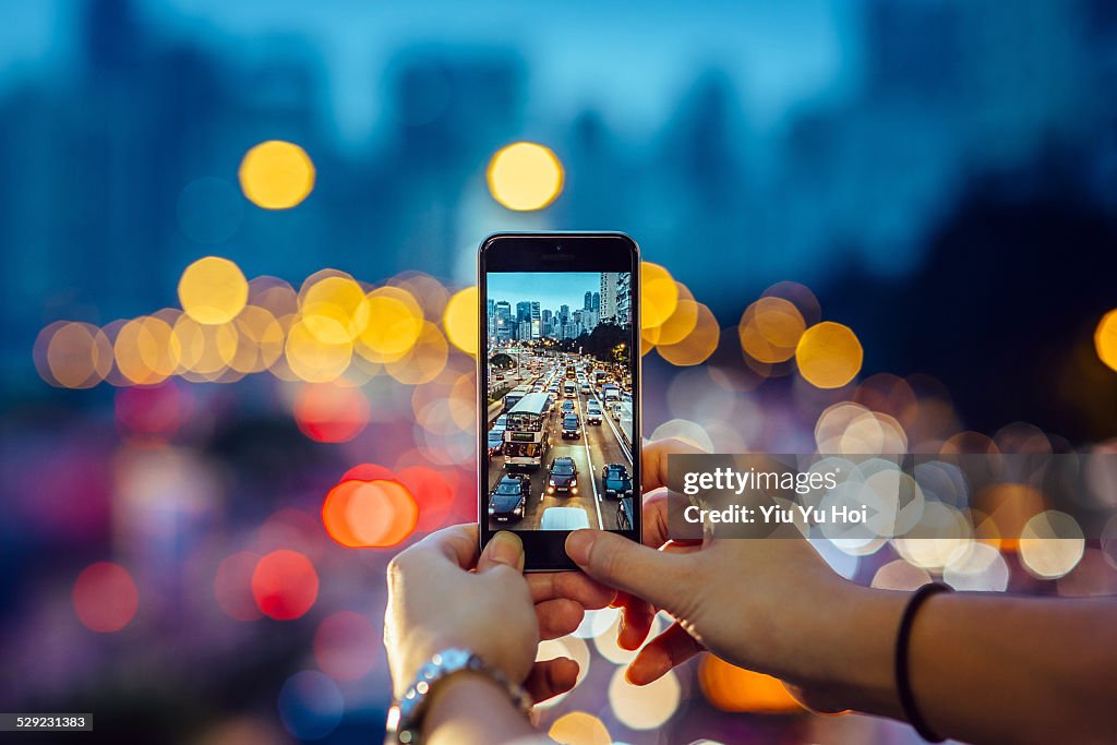 Woman capturing the busy traffic with smartphone