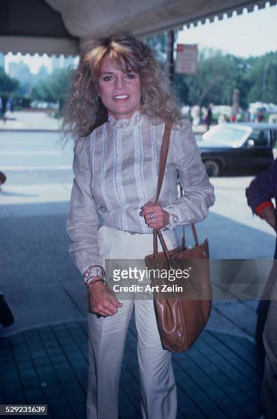 Dyan Cannon wearing a white casual outfit; under a marquee, New York, circa 1982.