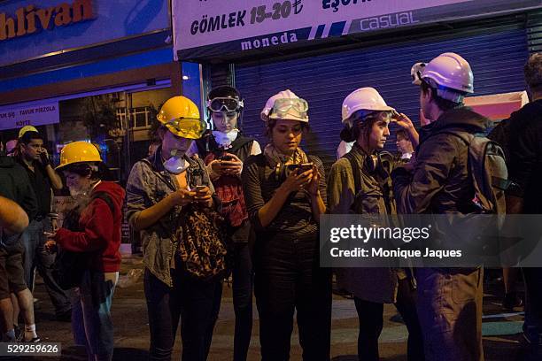 Girls check their phones as protesters build a wall across the main street in Sisli, Istanbul. Fires were set after the police pushed protesters...