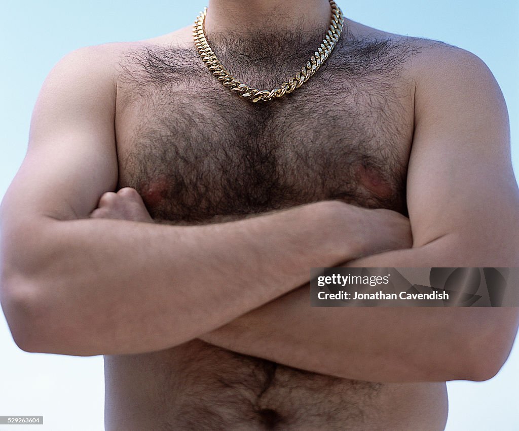 Hairy Chested Man with Gold Chain and Arms Crossed