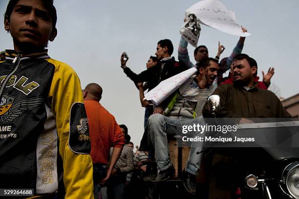 Men hold up signs against the Egyptian President in Tahrir Square. After the Janurary 25th revolution protesters occupied Tahrir Square in Cairo...