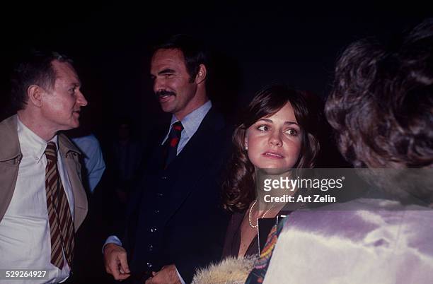 Sally Field with Burt Reynolds talking with friends; circa 1970; New York.