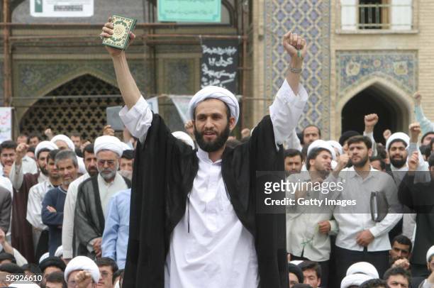 An Iranian cleric holds a copy of the Quran as he shouts anti-U.S. Slogans during a protest at the Faizieh religious school May 18, 2005 in the...