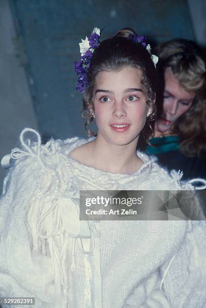 Brooke Shields wearing a white sweater and blue flowers in her hair; circa 1970; New York.