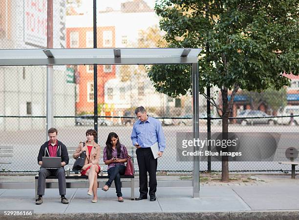 people waiting at bus stop - waiting fotografías e imágenes de stock