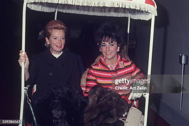 Elizabeth Taylor with Deborah Kerr in a golf cart; on vacation; circa 1970; New York.