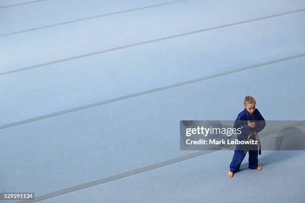 girl (8-9) wearing blue gi practicing - gi abbigliamento per arti marziali foto e immagini stock