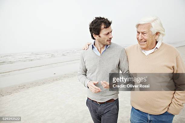 father and son talking on beach - dad advice stock pictures, royalty-free photos & images