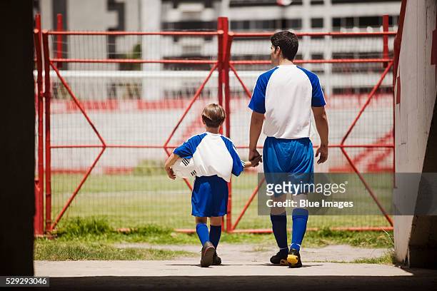 father and son entering soccer stadium - vintage football player stock pictures, royalty-free photos & images