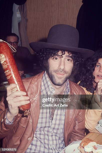 Elliott Gould with a salami at Katzen's Deli on the Lower East Side; circa 1970; New York.