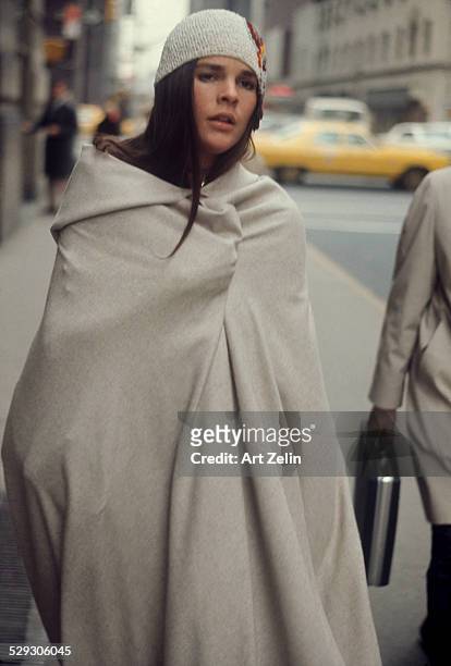 Ali MacGraw wrapped in a blanket walking on the street; circa 1970; New York.