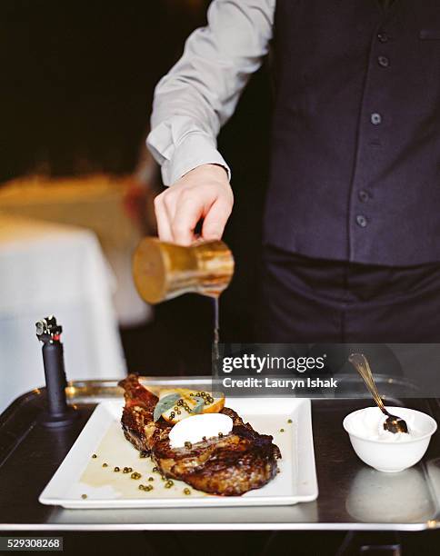 waiter flambeeing cote de beouf - gourmet steak stock pictures, royalty-free photos & images