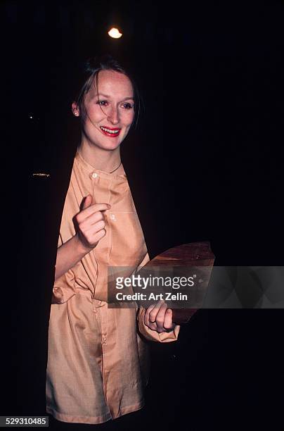 Meryl Streep wearing peach and carrying an award; circa 1970; New York.