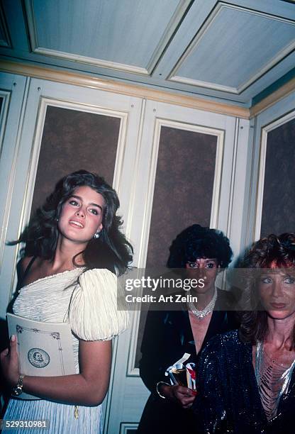 Brooke Shields wearing a white pleated formal dress in an elevator.; circa 1970; New York.