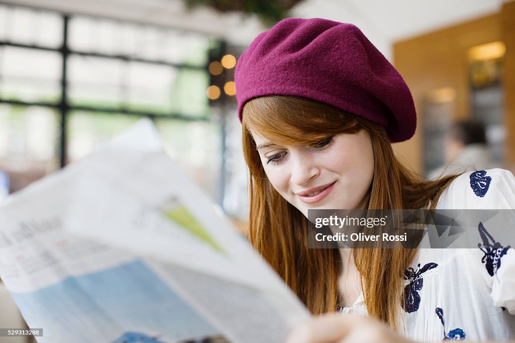 Young woman reading newspaper