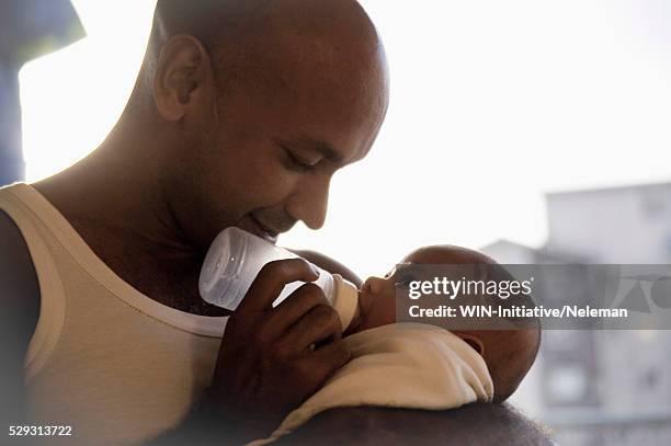 mid adult father feeding baby boy (0-1 months) - baby father hug side stock-fotos und bilder