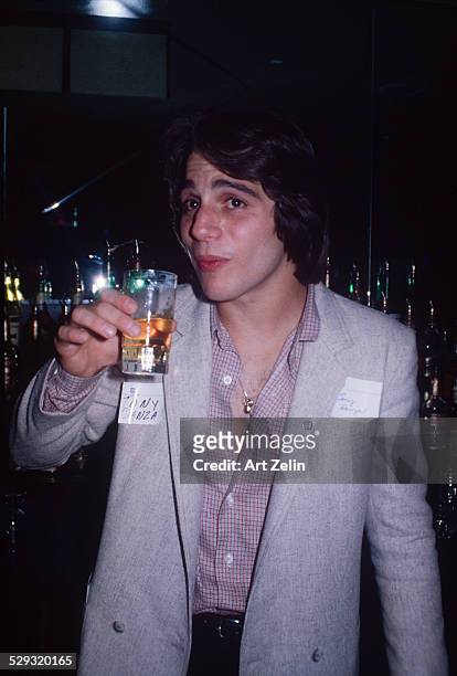 Tony Danza about to take a drink at a bar; circa 1970; New York.
