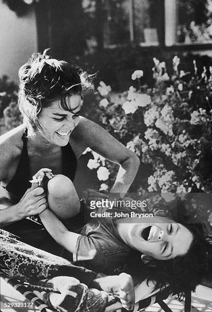 American actress Ali MacGraw tickles her son, Josh Evans, California, 1978.