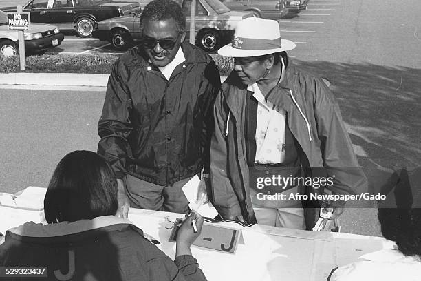 African-American citizens at Morgan State University at a table during a golf tournament, Baltimore, Maryland Original Caption Reads: 'Teammates Herb...