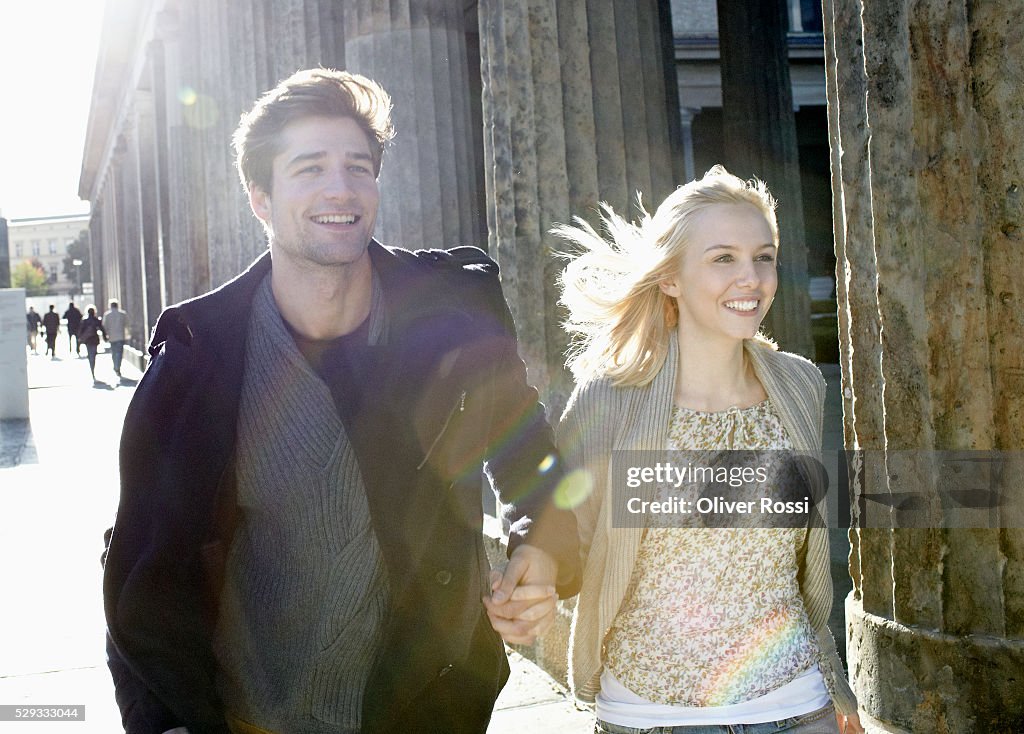Portrait of smiling young couple walking on street
