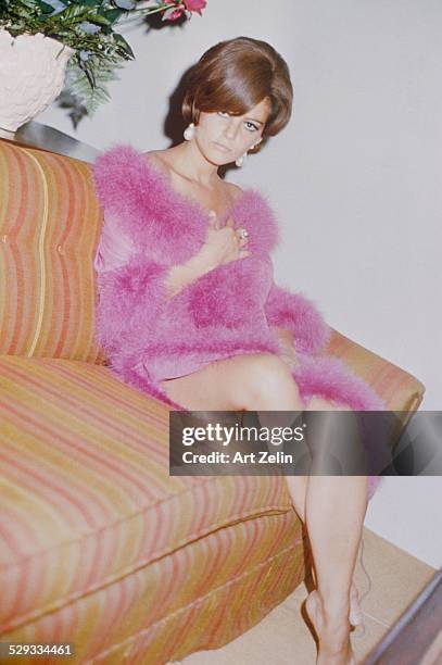 Claudia Cardinale at the Drake Hotel wearing a pink feather trimmed negligee; circa 1970; New York.