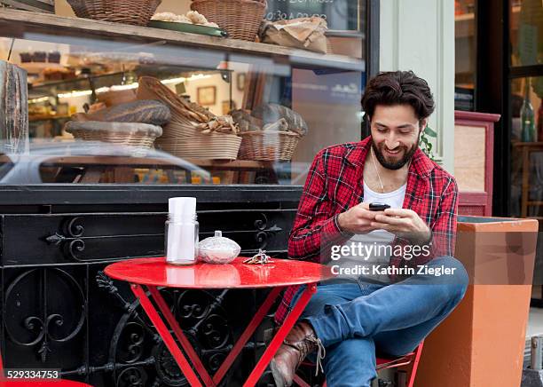 man looking at mobile phone in café - buenos aires cafe stock pictures, royalty-free photos & images