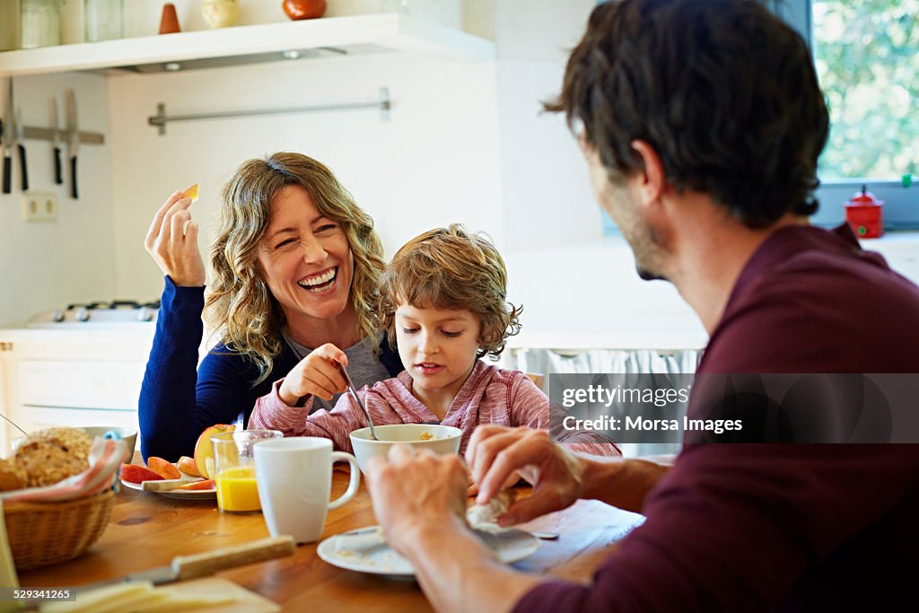 Happy family enjoying breakfast at table