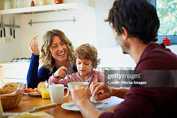 happy family enjoying breakfast at table - family at kitchen stockfoto's en -beelden