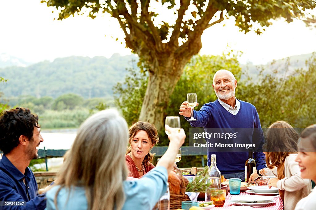 Senior couple enjoying meal with family in yard