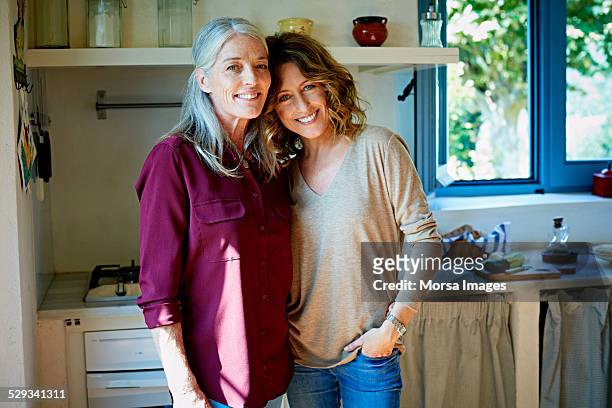 happy mother and daughter standing in kitchen - daughter stock-fotos und bilder
