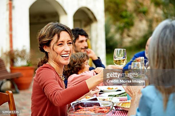 woman enjoying wine while having meal with family - spain wine stock pictures, royalty-free photos & images
