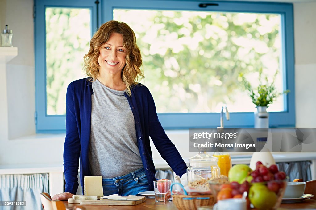 Happy woman at breakfast table in kitchen