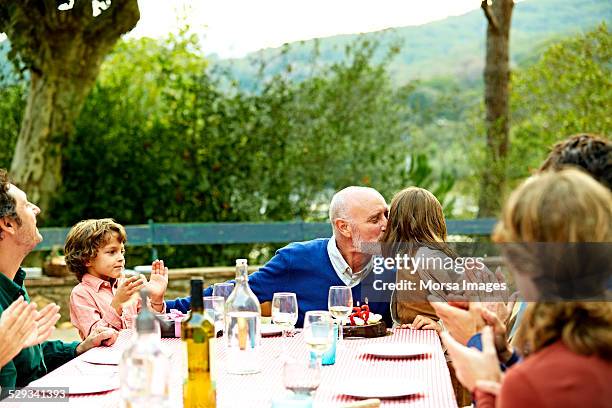 family celebrating birthday at outdoor meal table - outdoor party imagens e fotografias de stock