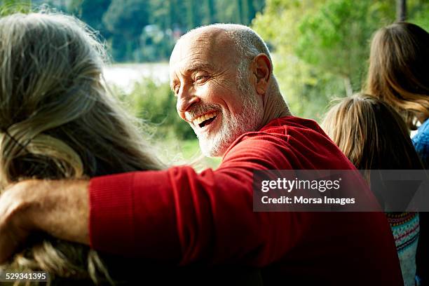 cheerful senior man looking at woman in yard - 70 anos imagens e fotografias de stock