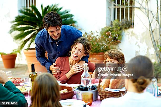 cheerful family enjoying at outdoor meal table - repas photos et images de collection