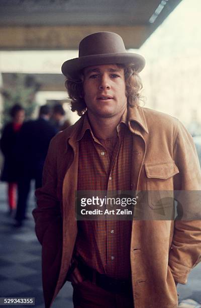 Ryan O'Neal in a hat and suede jacket; circa 1980; New York.