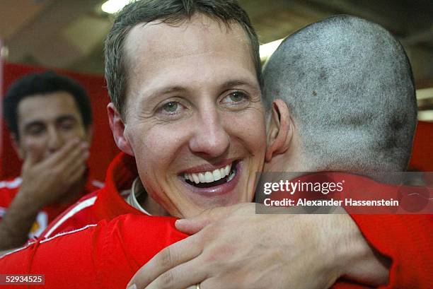 Von Japan 2003, Suzuka; Michael SCHUMACHER umarmt einem Ferrari-Techniker in der Box, der sich soeben seine Haare abrasieren lassen hat