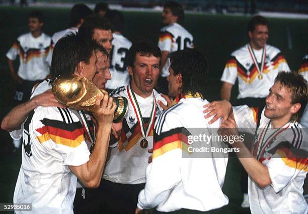 In Rom; Deutschland wird Fussballweltmeister 1990; v.lks.: Klaus AUGENTHALER mit WM - Cup, Andreas BREHME, Lothar MATTHAEUS, Pierre LITTBARSKI,...