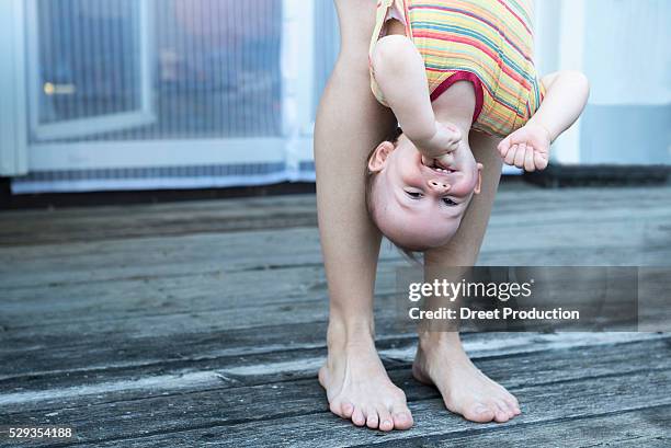 mother holding her baby son upside down and laughing, munich, bavaria, germany - male feet on face stock pictures, royalty-free photos & images