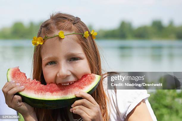 girl enjoying slice of watermelon at picnic, munich, bavaria, germany - blumenkrone stock-fotos und bilder