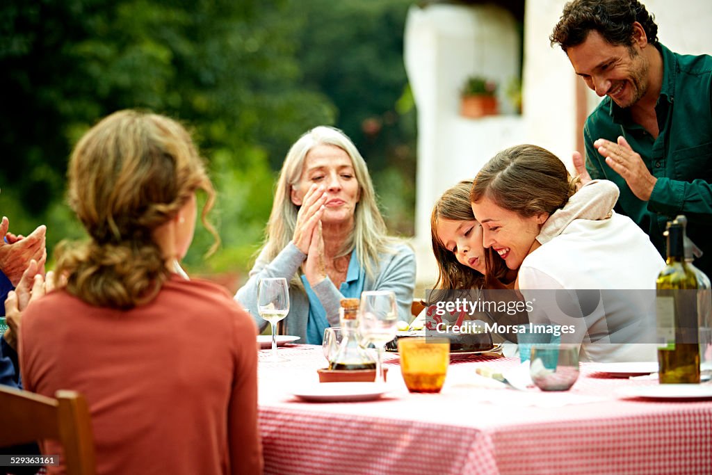 Family celebrating birthday at outdoor meal table