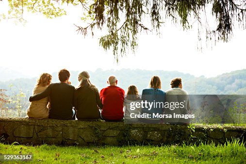 Multi-generation family relaxing on retaining wall Multi-generation family relaxing on retaining wall