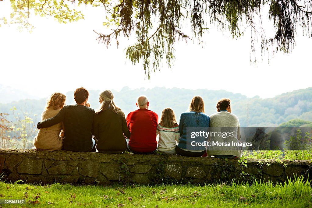 Multi-generation family relaxing on retaining wall