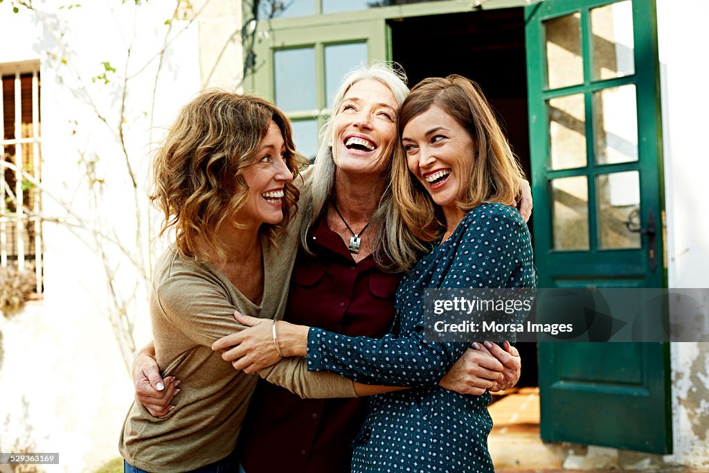 Mother and daughters embracing outdoors