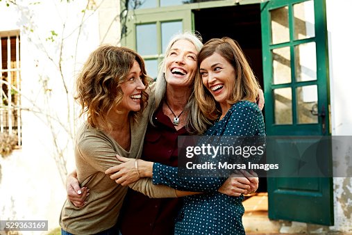Mother and daughters embracing outdoors Mother and daughters embracing outdoors