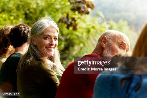 Senior woman sitting with family at park Senior woman sitting with family at park