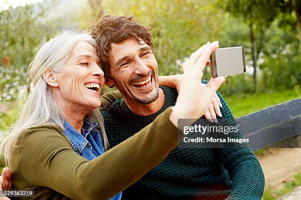 cheerful mother and son taking selfie in park - mom son stock pictures, royalty-free photos & images